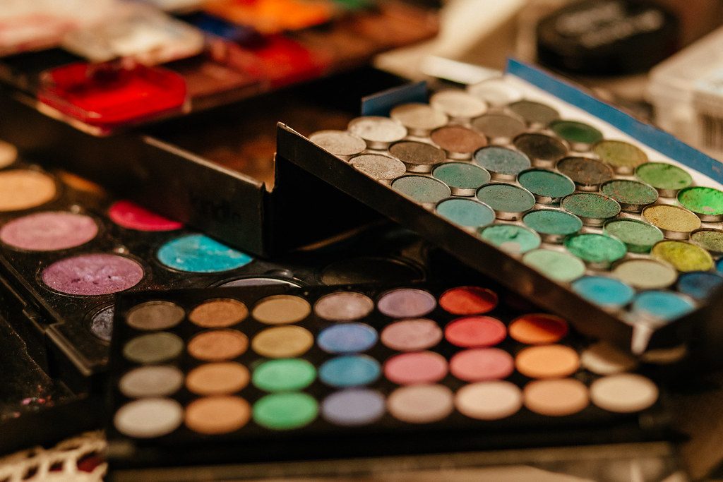 Colorful eyeshadow palettes stacked on a makeup table